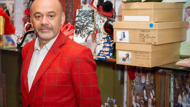 French shoe designer Christian Louboutin poses for photographers as he opens his first-ever retrospective exhibition at the Design Museum in London April 30, 2012. 