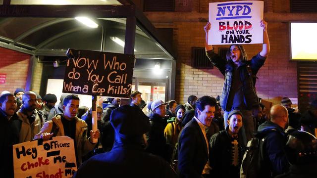 Protesters rallying against a grand jury's decision not to indict the police officer involved in the death of Eric Garner chant as they pass police while marching through Midtown in the early morning hours of Dec. 5, 2014, in New York. 