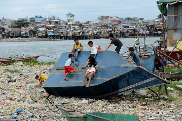 Children play on a boat in a shanty town at the port area in Manila