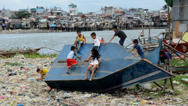 Children play on a boat in a shanty town at the port area in Manila 
