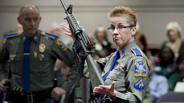 In this Jan. 28, 2013, file photo, firearms training unit Detective Barbara J. Mattson, of the Connecticut State Police, holds up a Bushmaster AR-15 rifle, the same make and model of gun used by Adam Lanza in the Sandy Hook School shooting, for a demonstr 