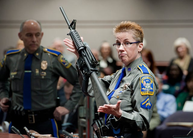 In this Jan. 28, 2013, file photo, firearms training unit Detective Barbara J. Mattson, of the Connecticut State Police, holds up a Bushmaster AR-15 rifle, the same make and model of gun used by Adam Lanza in the Sandy Hook School shooting, for a demonstr 