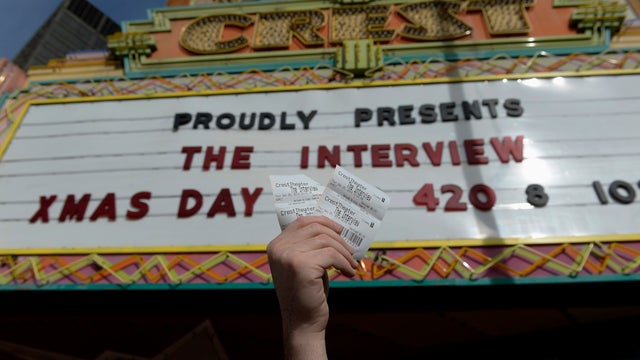 Tickets for the film "The Interview" are seen being held up by theater manager Donald Melancon at Crest Theater in Los Angeles on December 24, 2014 