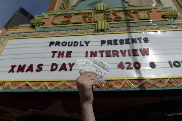 Tickets for the film "The Interview" are seen being held up by theater manager Donald Melancon at Crest Theater in Los Angeles on December 24, 2014 