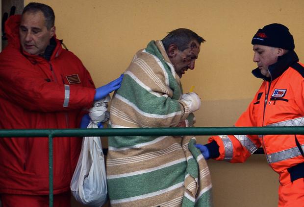 Injured passenger, among 49 evacuees from burning ferry, is helped by rescuers as he arrives aboard cargo ship "Siprit of Piraeus" at harbor of Bari, Itaaly on December 29, 2014 