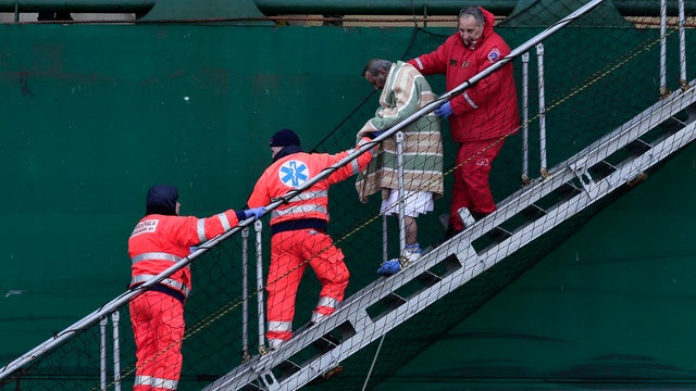 A wounded passenger is helped as he leaves the "Spirit of Piraeus" container ship at Bari harbor, after the car ferry Norman Atlantic caught fire 