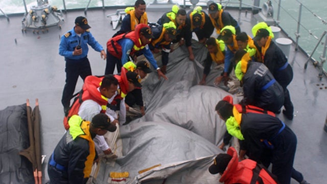​Royal Malaysian Navy sailors secure the emergency slide from AirAsia Flight 8501 