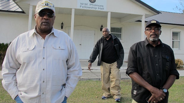 Alonzo Philmore, left, Harry Campbell, center, and Suwannee County NAACP President Leslie White stand in front of their church in Live Oak, Fla., Dec. 18, 2014. 