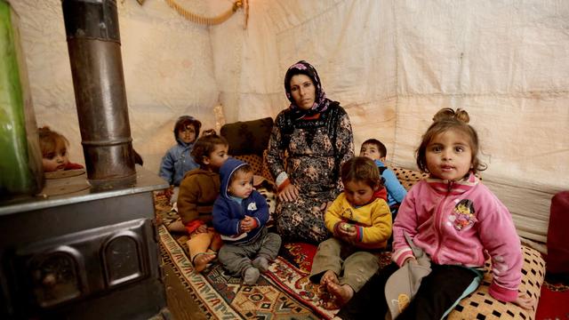 The mother of eleven children and who is currently six-months pregnant sits by the 'sobia', a traditional Middle Eastern diesel or wood-powered stove at an unofficial refugee camp in Jabaa, a village in the Bekaa Valley in Lebanon 