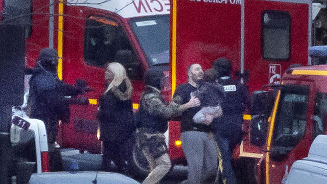 A security officer directs released hostages after police stormed a kosher market to end a hostage situation in Paris Jan. 9, 2015. 