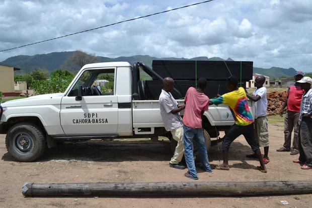 Mozambican men load coffins of victims of alcohol poisoning onto a pickup truck at the Chitima health center in Tete province 