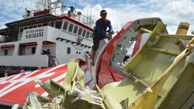 Indonesian worker cuts tail of AirAsia Flight 8501 in Kumai on January 12, 2015, after debris from crash was retrieved from the Java Sea 