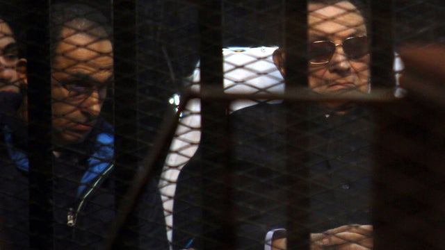 Egypt's former president Hosni Mubarak (R) and his son Gamal sit behind bars during a court hearing on Nov. 29, 2014 in the capital Cairo. 