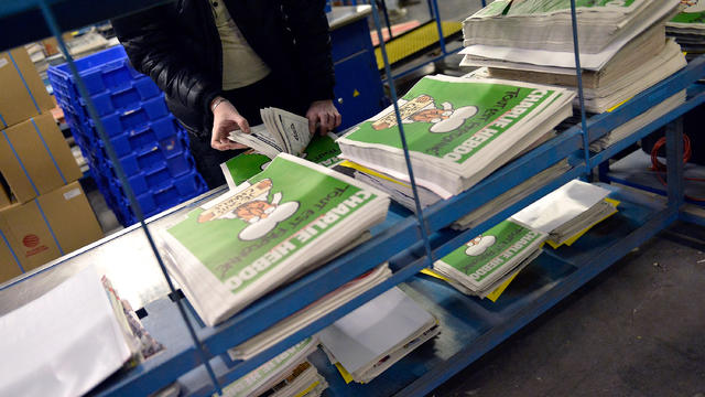 A worker prepares the new edition of Charlie Hebdo for delivery in a press distribution center in the Paris suburbs 