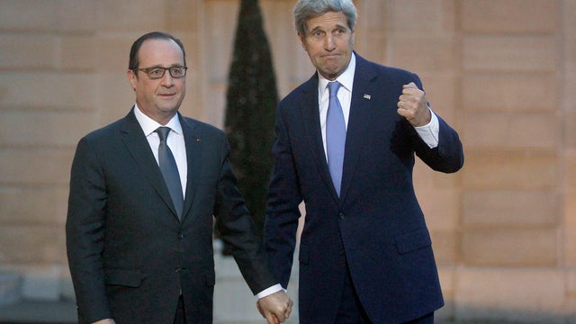 French President Francois Hollande (L) welcomes Secretary of State John Kerry prior to a meeting at the Elysee Presidential Palace in Paris 