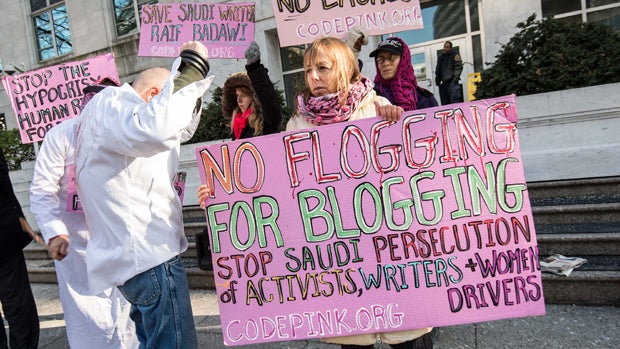 Protesters simulate a flogging in front of the Saudi Embassy in Washington, D.C., Jan. 15, 2015, during a demonstration against the 10-year prison sentence and 1,000 lashes of Saudi activist Raif Badawi for "insulting Islam" in a blog post. 