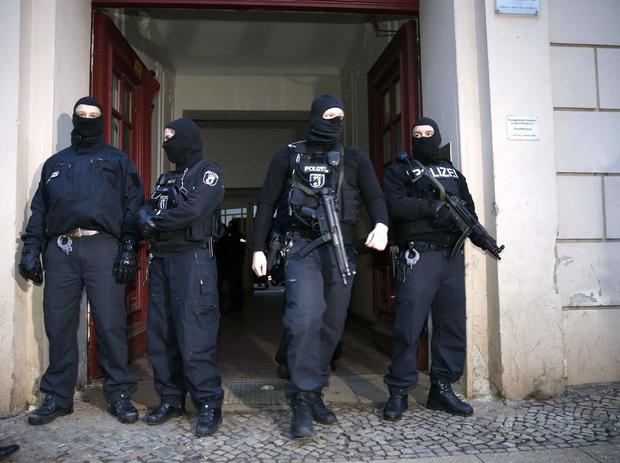German special police units stand in front of an entrance of an apartment building in the Wedding district in Berlin 