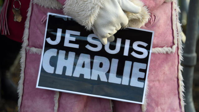 A woman holds a placard reading "Je suis Charlie" (I am Charlie) during the funeral of French cartoonist and Charlie Hebdo editor Stephane "Charb" Charbonnier Jan. 16, 2015, in Pontoise, outside Paris. 