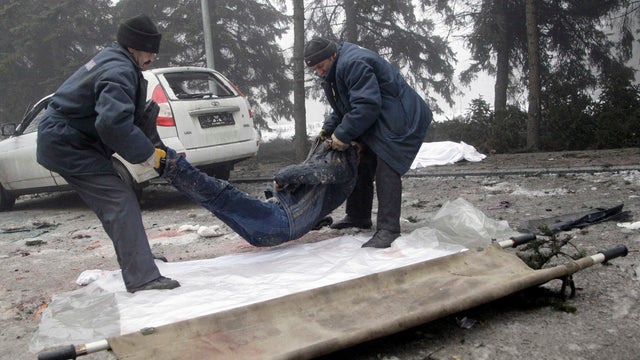 Men put the body of a victim of shelling onto a stretcher to load it into a vehicle at a site hit by shelling in Donetsk Jan. 30, 2015.  