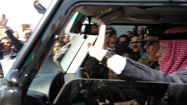 Jordan's King Abdullah waves to crowds after returning from the United States at the Queen Alia International Airport in Amman 