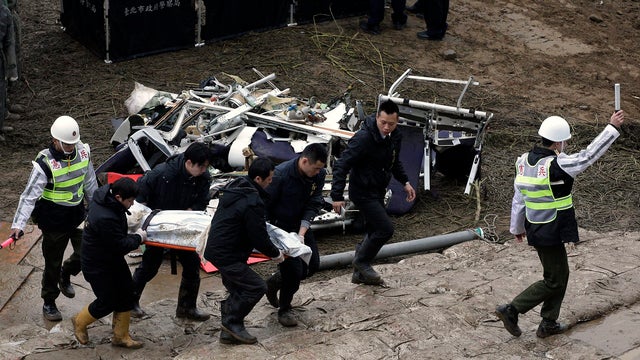 Emergency personnel carry the body of a passenger who died in the TransAsia Airways Flight GE235 plane crash in New Taipei City 