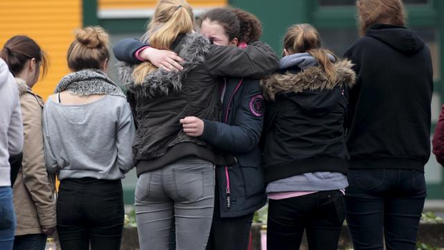 Students hug in front of the Joseph-Koenig-Gymnasium high school in Haltern-am-See 