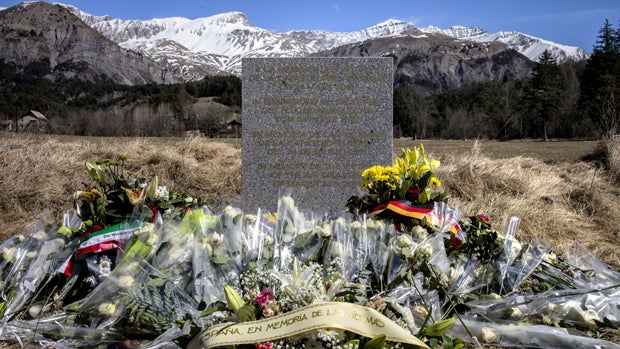 Flowers are pictured around a memorial, carved in French, German, Spanish and English, in memory of the victims of the Germanwings Airbus A320 crash in the small village of Le Vernet, French Alps, March 27, 2015, near the site where plane crashed March 24 
