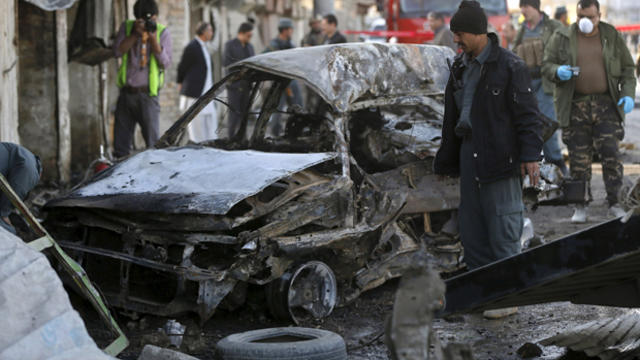 Afghan policemen investigate at the site of a suicide attack in Kabul April 10, 2015. 