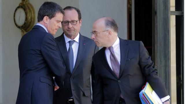 French Prime Minister Manuel Vall, left, and interior minister Bernard Cazeneuve, right, leave the Elysee Palace in Paris, France, after a cabinet meeting while French President Francois Hollande looks on 