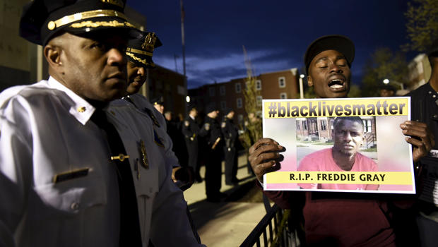 A demonstrator holds a sign in front of the Baltimore Police Department Western District station during a protest against the death in police custody of Freddie Gray in Baltimore April 23, 2015. 