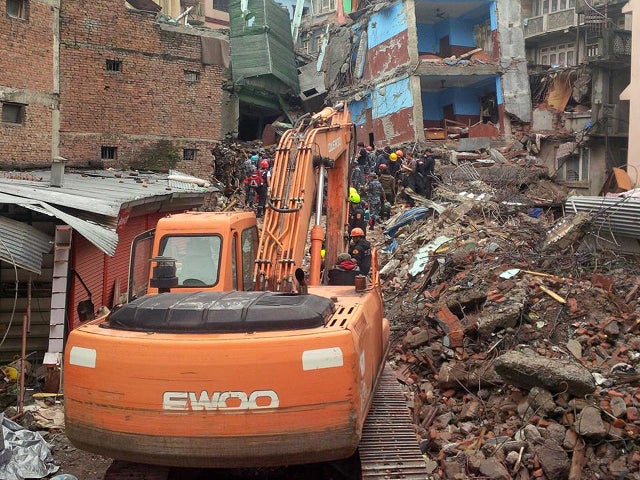 Rescue workers climb atop the rubble of the leveled Hilton Hotel in Kathmandu, Nepal, after hearing a voice from beneath the wreckage