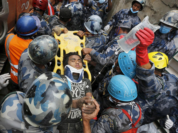 Earthquake survivor Pemba Tamang, 15, is rescued by the Armed Police Force from the collapsed Hilton Hotel 