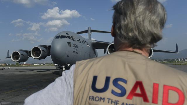 A USAID officer watches as a U.S. military C-17 cargo plane taxis to a stop at Kathmandu's international airport 