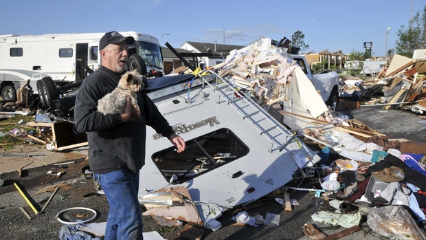 Damon Braley carries his mother's dog, Sammy, which he rescued from under the wreckage of his parents' RV, at the Roadrunner RV Park in Oklahoma City, Oklahoma, May 7, 2015. 