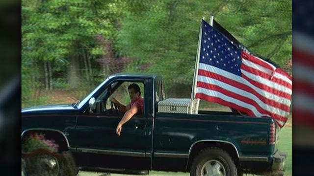 ​Peyton Robinson, 18, drives his truck displaying the American flag and the POW-MIA flag. 