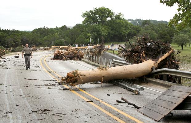 Department of Public Safety Trooper Marcus Gonzales walks on Highway 12 bridge over Blanco River, which was blocked by large trees after flooding in Wimberly, Texas, on May 24, 2015 