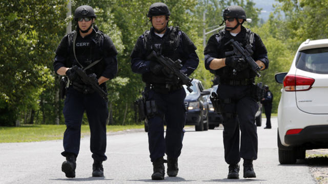 Law enforcement officials search a street near the Clinton Correctional Facility in Dannemora, New York, June 10, 2015. 