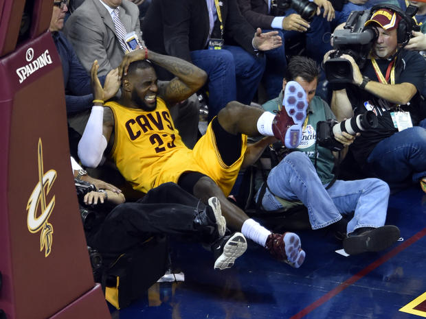 LeBron James falls into cameraman on sidelines during second quarter of Game 4 of NBA Finals at Quicken Loans Arena in Cleveland on June 11, 2015; Warriors won, 103-82 