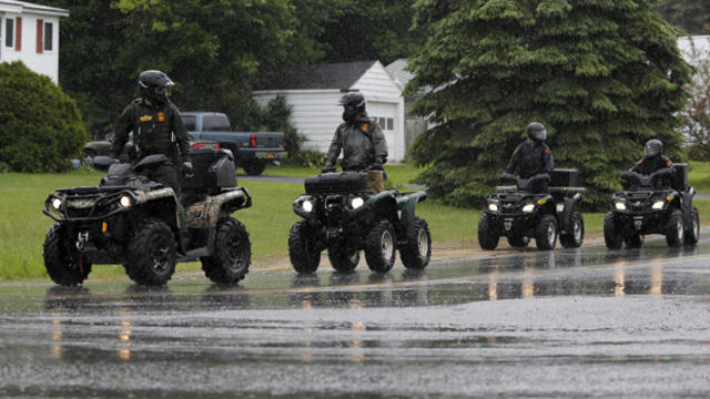 Law enforcement agents ride all-terrain vehicles during a search of a wooded area near Cadyville, New York, June 12, 2015. 