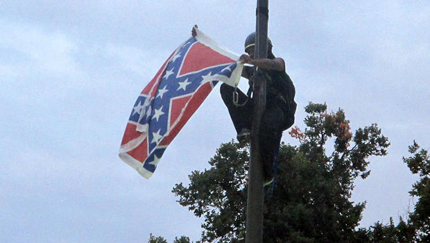 Bree Newsome of Charlotte, N.C., removes the Confederate battle flag at a Confederate monument at the Statehouse in Columbia, S.C., June 27, 2015. 