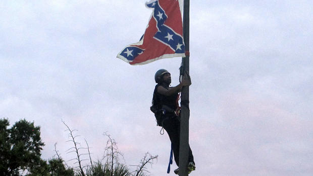 Bree Newsome of Charlotte, N.C., climbs a flagpole to remove the Confederate battle flag at a Confederate monument in front of the Statehouse in Columbia, S.C., June 27, 2015. 