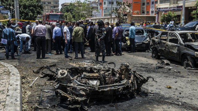 Egyptian security forces stand guard at the site of a bomb that targeted the convoy of the Egyptian state prosecutor, Hisham Barakat, in the capital Cairo 