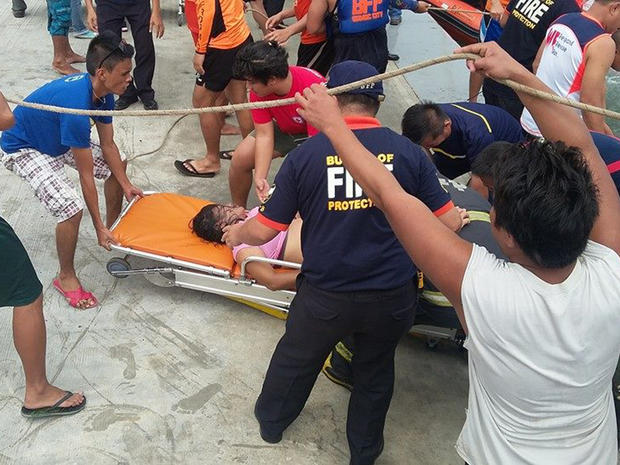 A passenger rescued from the capsized ferry MB Nervana is brought ashore at the port of Ormoc in the central Philippines 