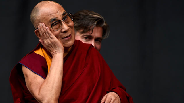 Dalai Lama shares a light moment with the crowd as Patti Smith performs on the Pyramid stage at Worthy Farm in Somerset during the Glastonbury Festival in Britain June 28, 2015. 