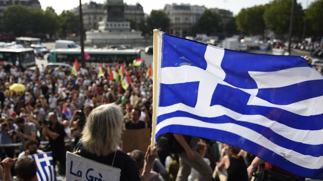 ​A protester holds a Greek flag as she takes part in a rally in support of the people of Greece at the "Place de la Bastille" in Paris  