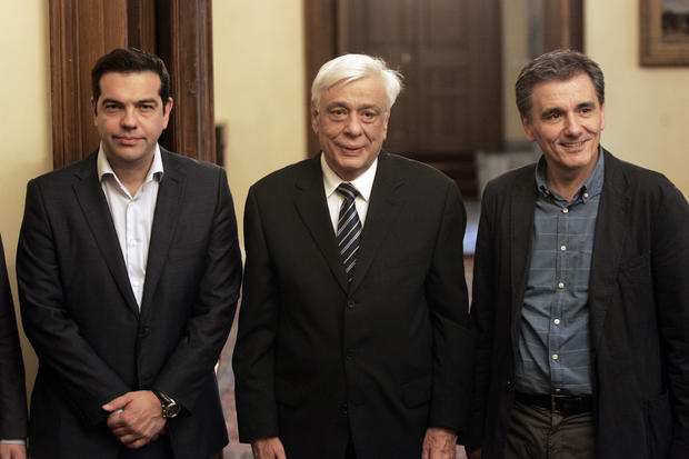 Greece's Prime Minister Alexis Tsipras (L), Greek President Prokopis Pavlopoulos (C) and the new Greek Finance Minister Euclid Tsakalotos pose for the photographers at the presidential palace during the swearing in ceremony of the new finance minister Euclid Tsakalotos in Athens, Greece 