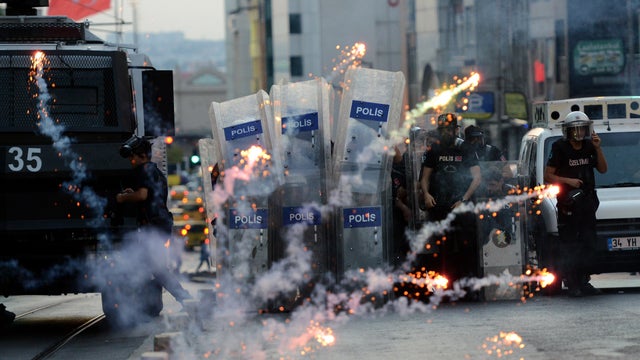 Turkish riot police use rubber bullets to disperse protesters as protestors fire fireworks at Kadikoy district in Istanbul, a day after a suicide bomb attack blamed on the Islamic State killed 32 people in the southern Turkish town of Suruc 