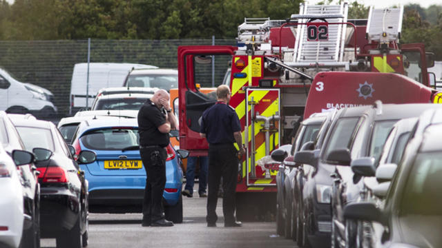 Members of the emergency services work the scene of a plane crash at a car park next to Blackbushe Airport in Hampshire, England, Aug. 1, 2015. 