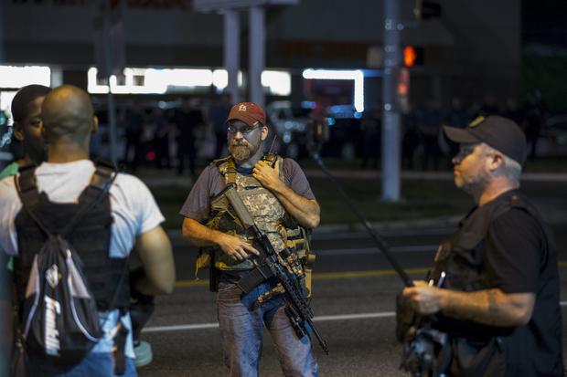 Members of "Oath Keepers" walk with their personal weapons on street during protests in Ferguson, Missouri on August 11, 2015 