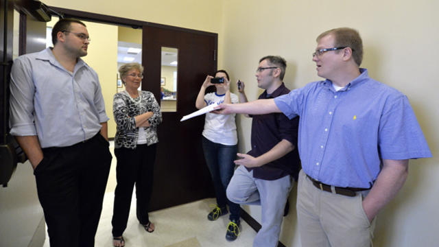 David Ermold, right, attempts to hand Rowan County clerks Nathan Davis, left, and Roberta Earley, second from left, a copy of the ruling from U.S. District Court Judge David Bunning instructing the county to start issuing marriage licenses, in Morehead, K 
